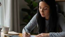 A woman filling out a 1099 form. 