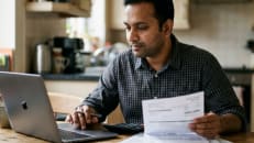 Person reviewing credit card debt after consolidation.