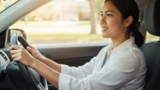 A student driving her car. 