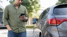 Driver deciding whether to file a car insurance claim after minor damage.