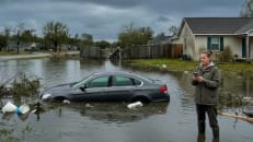A woman contacting her car insurance provider after a rain storm. 