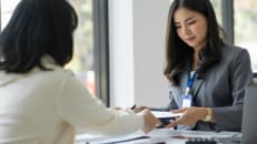 A woman working with a financial professional to help her understand her credit card interest rates during a recession. 