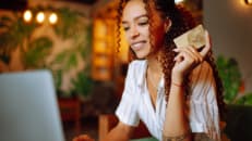A woman spending money on her credit card due to new defaults.