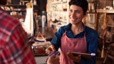 A small business owner using her POS system through her credit card company. 