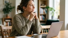 A woman deciding between Freedom Debt Relief and National Debt Relief for debt settlement.