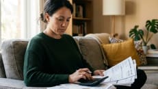 Woman reviewing her bills to understand how debt settlement works.