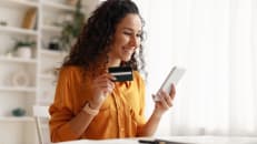 A woman holding her business credit card. 