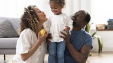 A man and a woman with their child wondering about whole life insurance and whether it's worth it. 