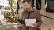 Person reviewing RV loan financing options next to a camper.