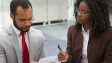 A man and a woman learning how to refinance a business loan. 
