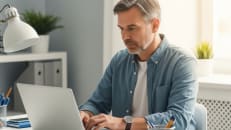 A man sitting at his desk doing research about tax deductible donations. 