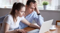 A young couple learning about tax scams to watch out for in 2025. 