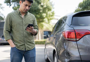 Driver deciding whether to file a car insurance claim after minor damage.