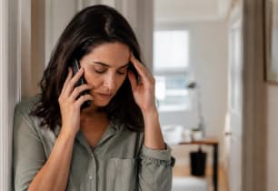 Woman on the phone with a debt collector, feeling stressed about her rights.