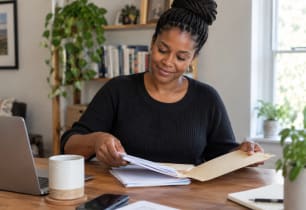 Woman organizing her bills after learning about combining debt into one payment.