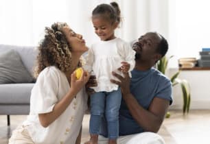 A man and a woman with their child wondering about whole life insurance and whether it's worth it. 