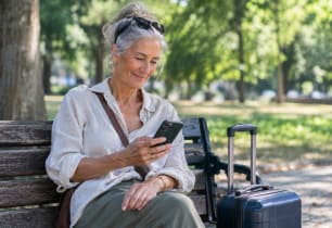 Senior woman reviewing travel insurance for seniors before a trip.