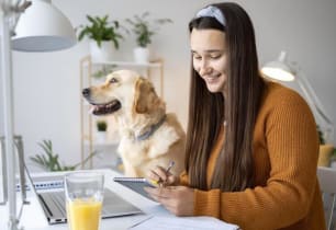 A woman sitting with her dog learning about the types of pet insurance.
