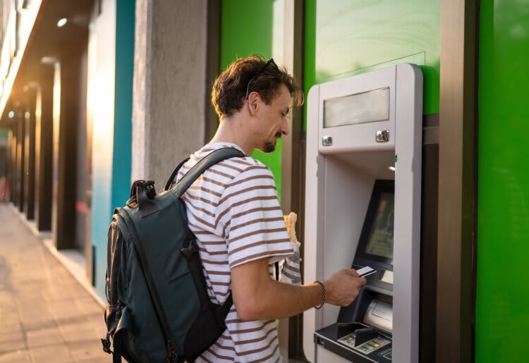 A man withdrawing money from an ATM. 