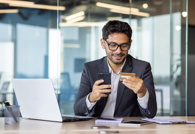 A man making strategic spending charges with his business credit card. 