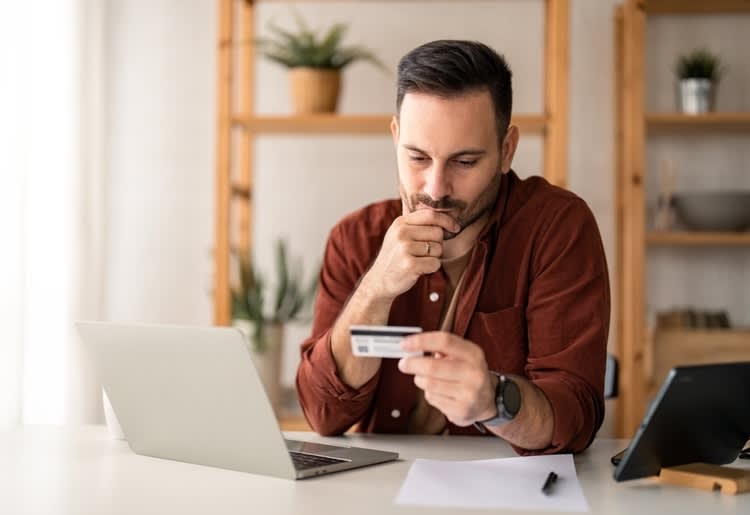 A man consider consolidating his credit card. 