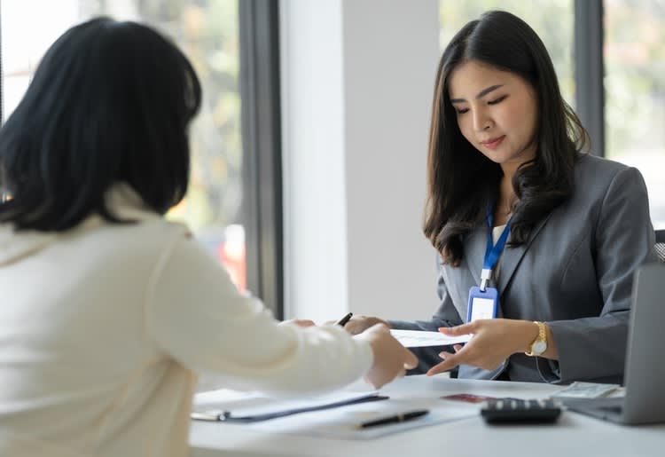 A woman working with a financial professional to help her understand her credit card interest rates during a recession. 