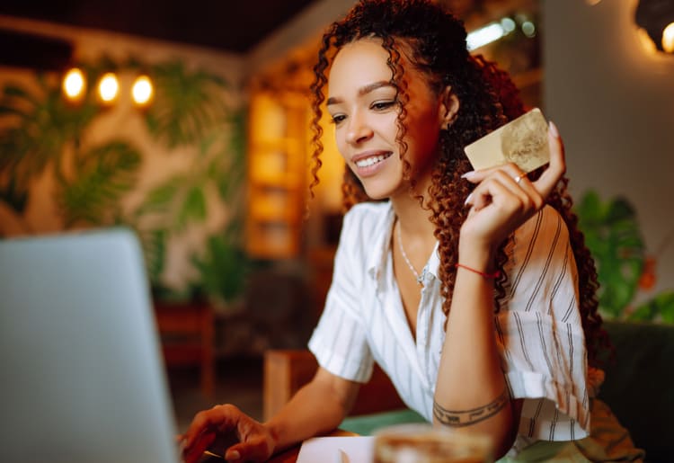 A woman spending money on her credit card due to new defaults.