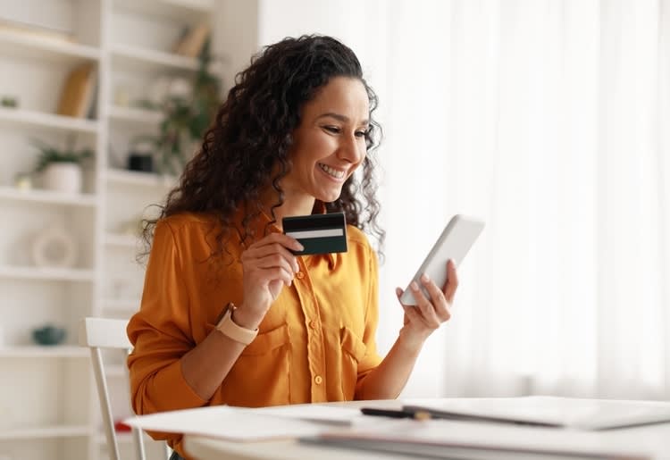 A woman holding her business credit card. 
