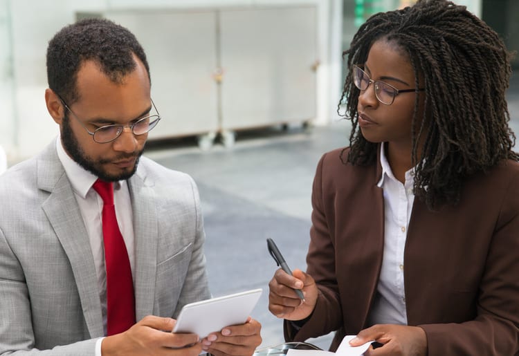 A man and a woman learning how to refinance a business loan. 
