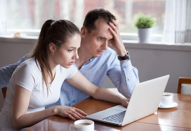 A young couple learning about tax scams to watch out for in 2025. 