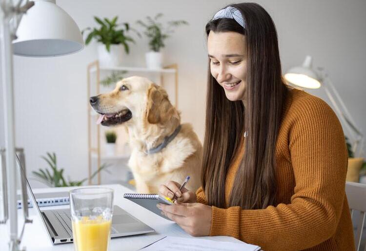 A woman sitting with her dog learning about the types of pet insurance.