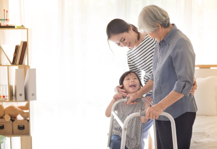 An elderly woman in long-term care being helped by her daughter and grand daugther. 